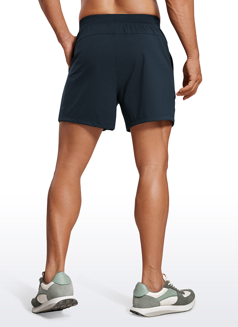 CRZ YOGA Men's Train Relaxed Fit On the Travel Linerless Shorts 5'' True Navy @model_info:Mazi
