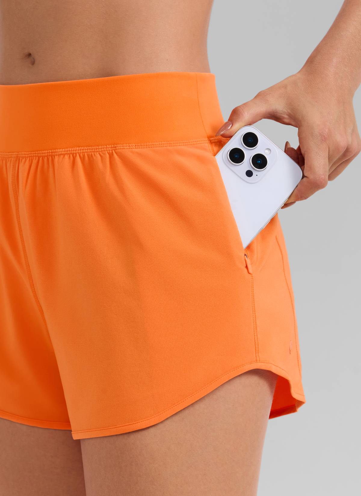 CRZ YOGA Women's Feathery-Fit Soft Mid Waisted Shorts 3” with Pockets Liner Sparkle Orange @model_info:Aline